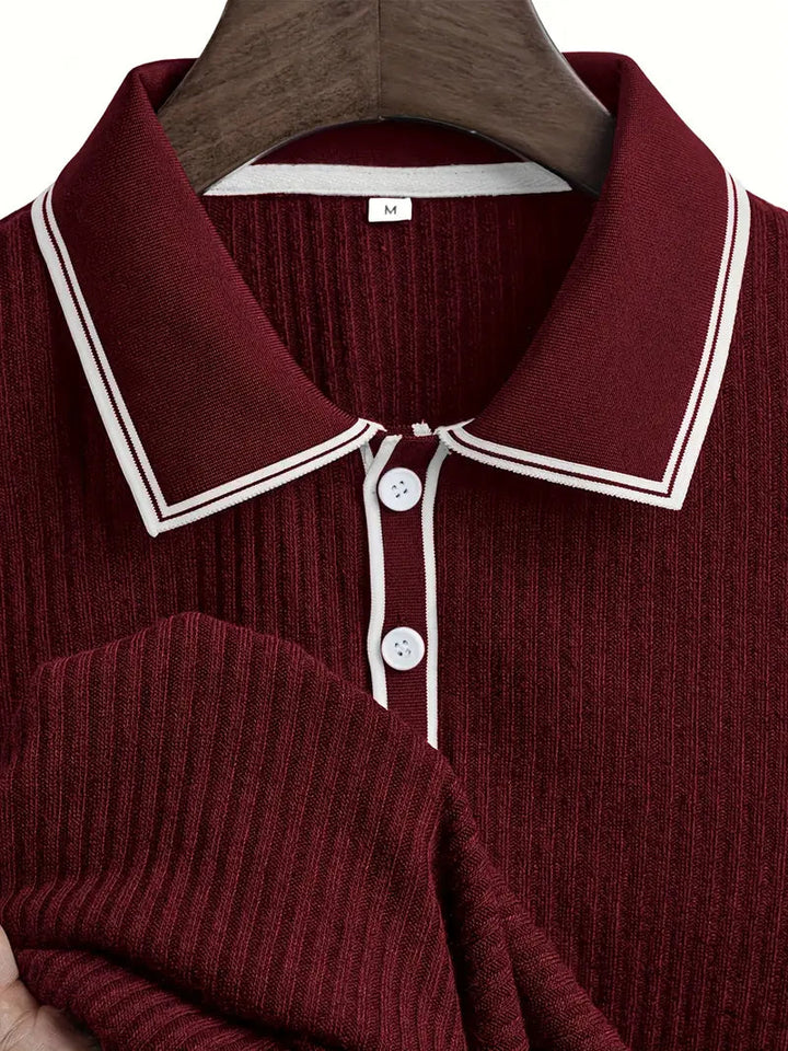 Dunkelrotes, geripptes Herren-Poloshirt mit weiß abgesetztem Kragen, Knopfleiste und Größe M auf einem Kleiderbügel.