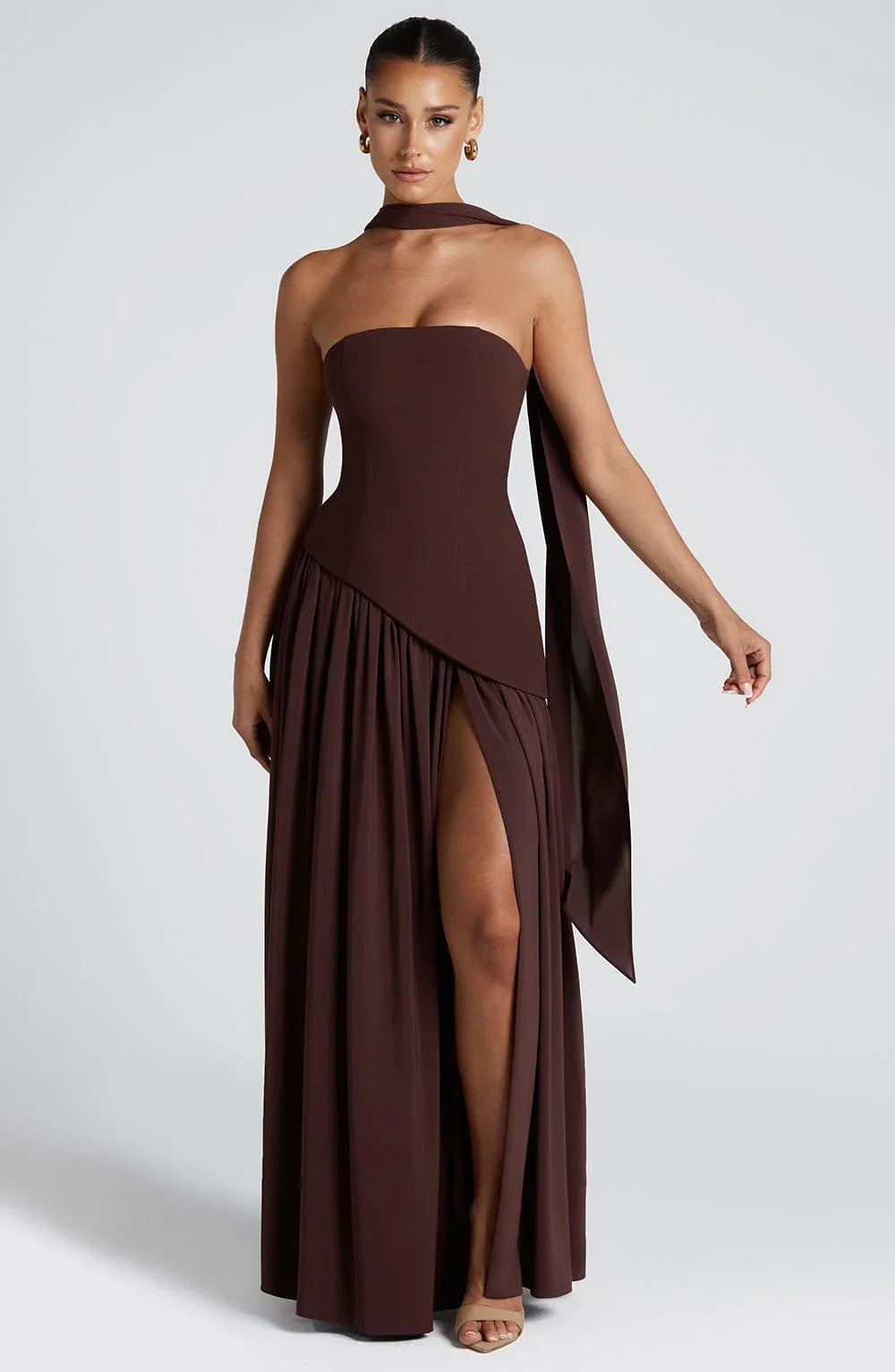 Dunkelbraunes, trägerloses Maxikleid mit Corsagen-Oberteil, hohem Beinschlitz und elegantem Schaltuch-Detail am Rücken.