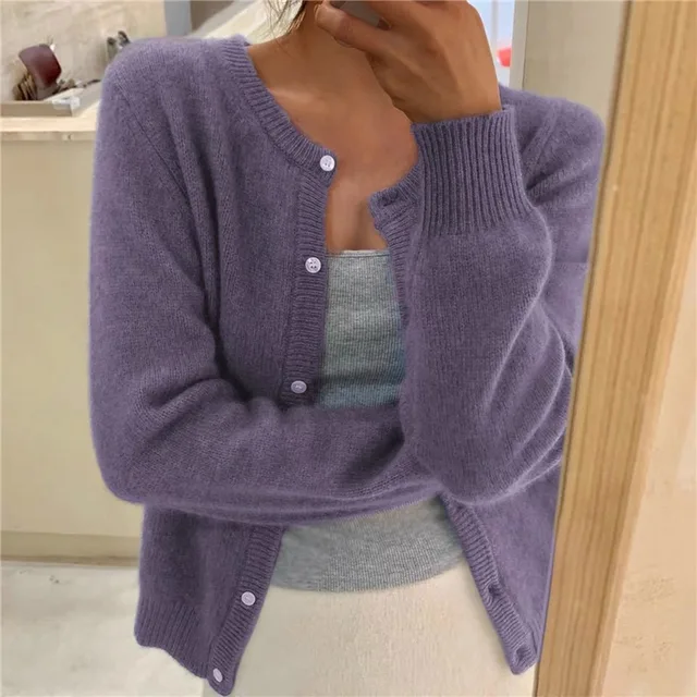 Lila Strickjacke mit Rundhalsausschnitt, Knopfleiste und gerippten Bündchen, getragen vor einem Spiegel.