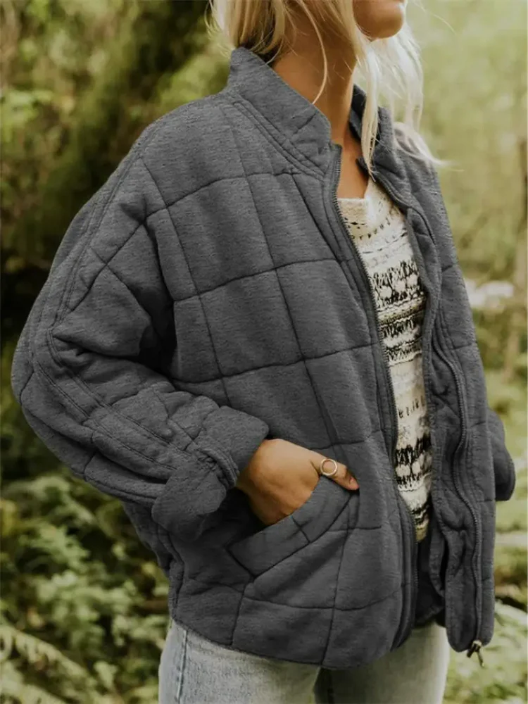 Dunkelgraue, locker geschnittene Steppjacke mit Karomuster, Stehkragen und praktischem Reißverschluss für die Übergangszeit.