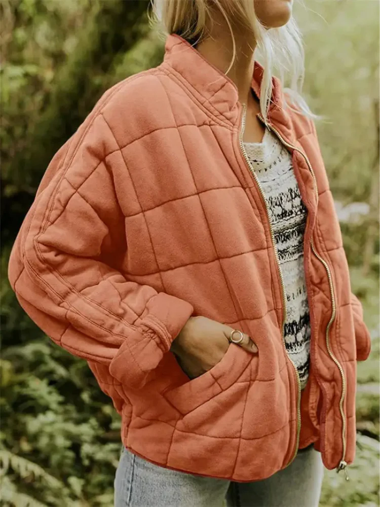 Locker geschnittene, korallenrote Steppjacke mit Karomuster, Stehkragen und praktischem Reißverschluss für die Übergangszeit.