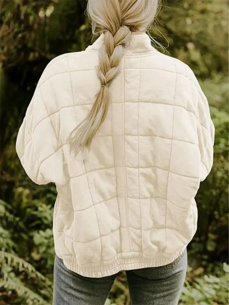 Beige gesteppte Damen-Steppjacke mit modernem Karomuster, Stehkragen und lockerer Passform für die Übergangszeit.