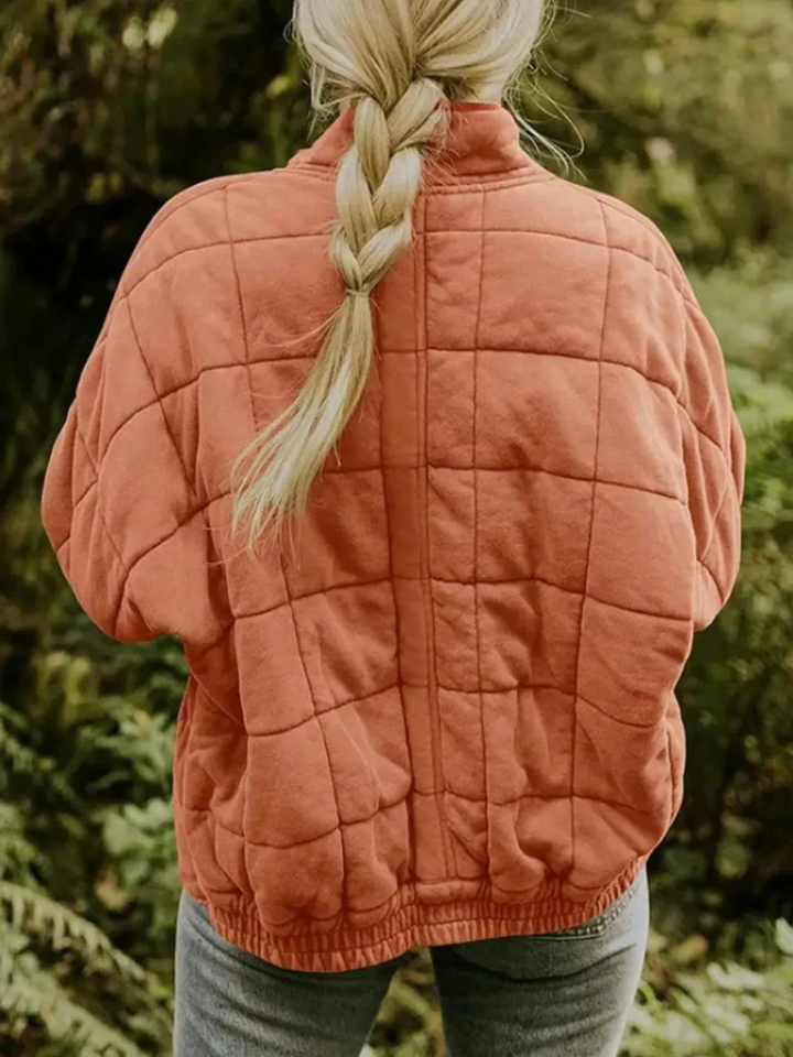 Rostrote, locker geschnittene Damen-Steppjacke mit modernem Karomuster, Stehkragen und bequemem Rippbündchen am Saum.