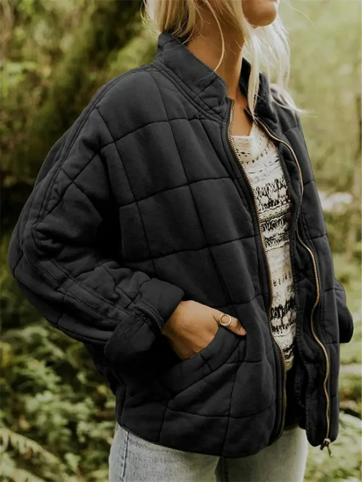 Schwarze, locker geschnittene Steppjacke mit Karomuster, Stehkragen und praktischem Reißverschluss für die Übergangszeit.