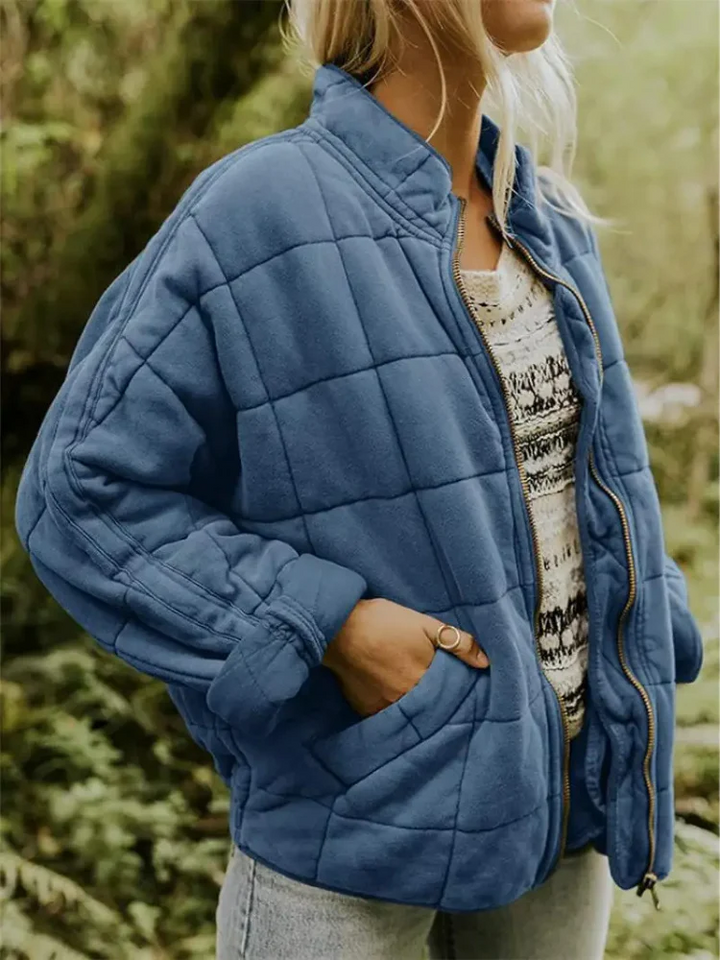 Blaue, locker geschnittene Damen-Steppjacke mit Karomuster, Stehkragen und praktischem Reißverschluss für die Übergangszeit.