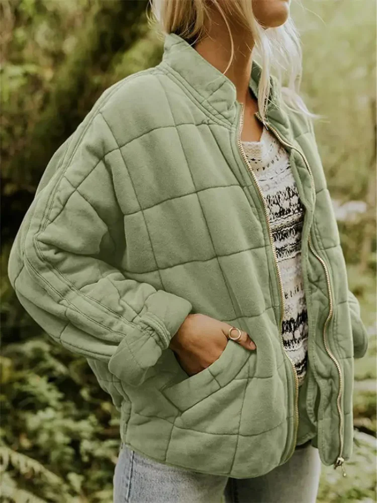 Salbeigrüne Damen-Steppjacke mit Karomuster, Stehkragen und Reißverschluss in lockerer Passform für die Übergangszeit.