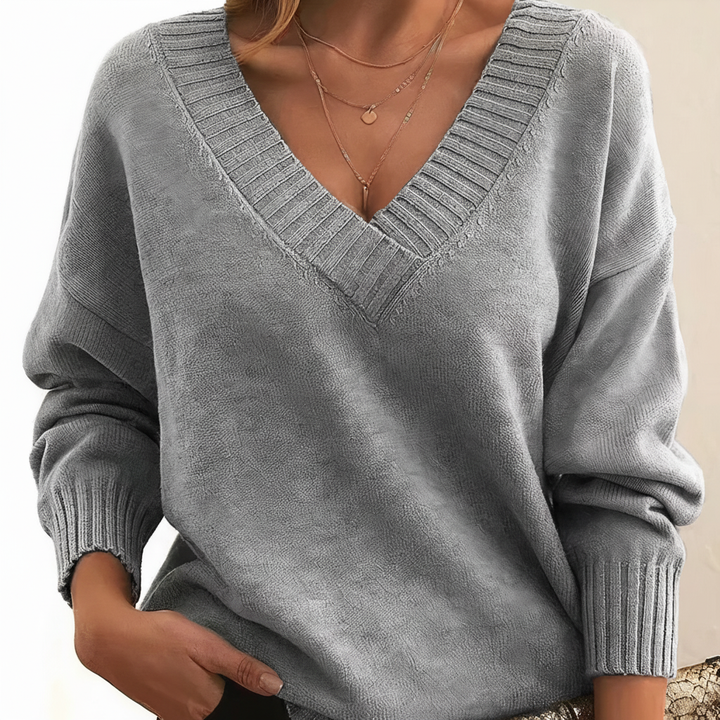 Grauer Damen-Pullover mit elegantem V-Ausschnitt, weichem Strickmaterial und gerippten Bündchen für einen stilvollen Look.