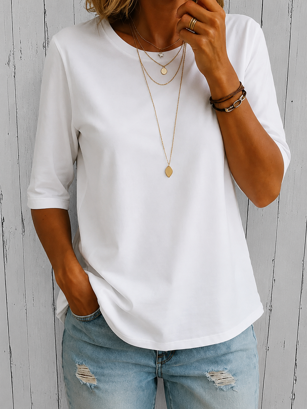 Weißes Annika Damen-Shirt mit Rundhals und Halbarm-Ärmeln aus weichem, fließendem Material kombiniert mit Jeans.