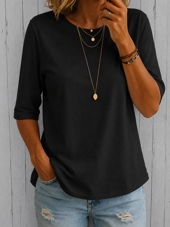 Schwarzes Annika Damen-Shirt mit Rundhals und Halbarm-Schnitt in lockerer Passform, kombiniert mit einer Jeans.