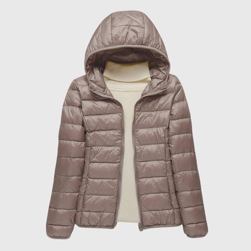 Taupefarbene, leicht gesteppte Damenjacke Anouk mit Kapuze und durchgehendem Reißverschluss über einem cremeweißen Pullover.