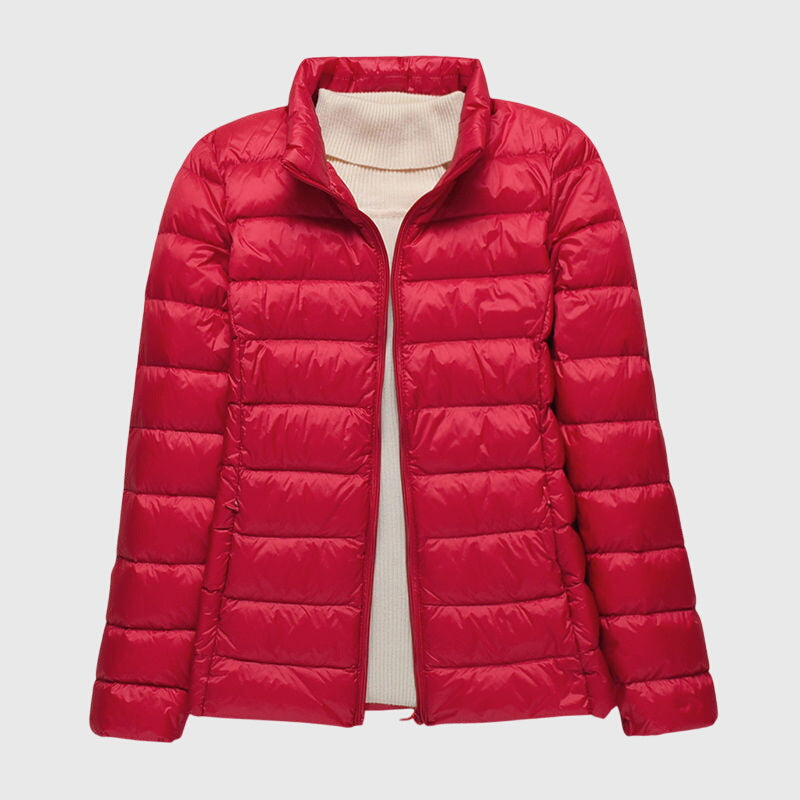 Rote, leicht gesteppte Anouk Damenjacke mit Stehkragen und Reißverschluss über einem beigen Rollkragenpullover.