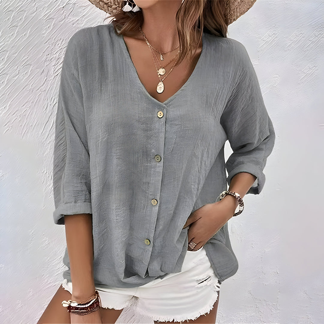 Graue Damen-Leinenbluse mit V-Ausschnitt, Knopfleiste und lässig gekrempelten Ärmeln für einen sommerlichen Look.