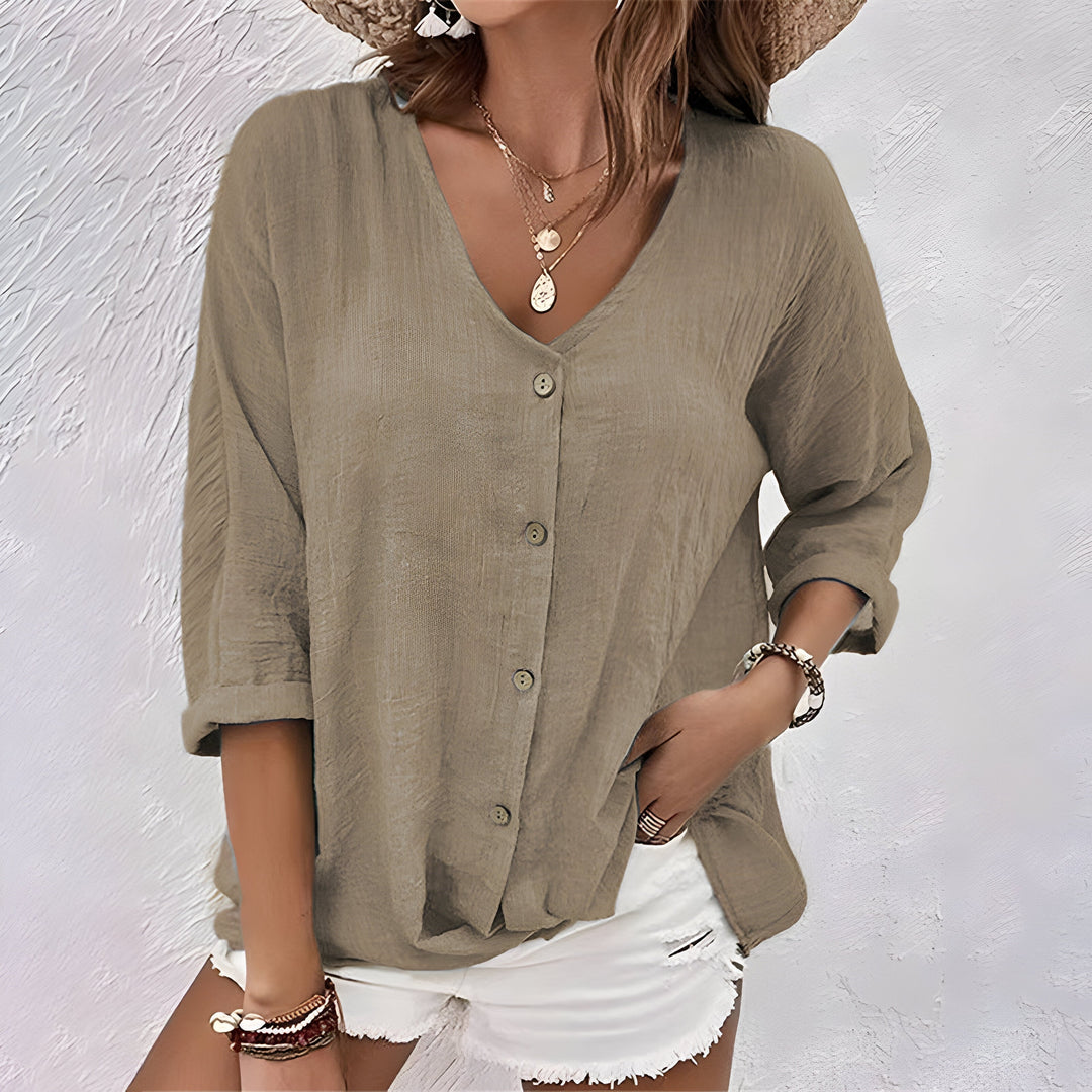 Beige Leinenbluse mit V-Ausschnitt, Knopfleiste und lässig gekrempelten Ärmeln für einen entspannten Sommer-Look.