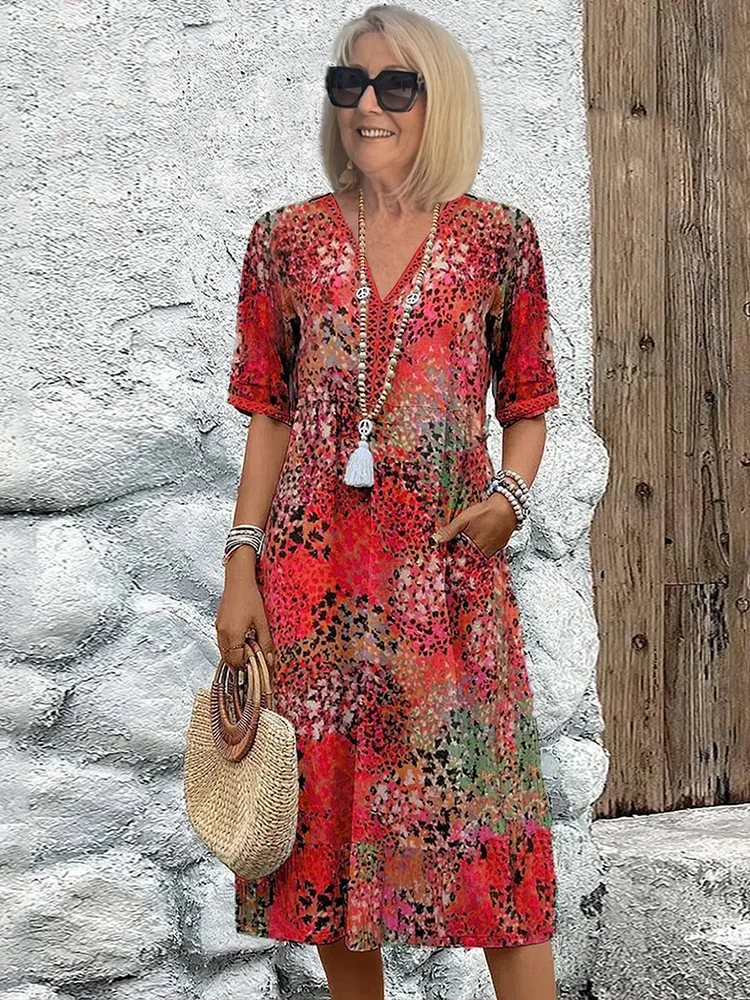 Buntes Midikleid mit V-Ausschnitt, Blumenmuster, kurzen Ärmeln und praktischen Seitentaschen für den Sommer.
