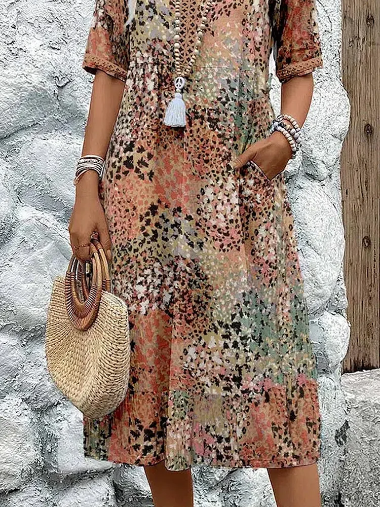 Buntes Midikleid mit Blumenmuster, V-Ausschnitt, kurzen Ärmeln und praktischen Seitentaschen im sommerlichen Stil.