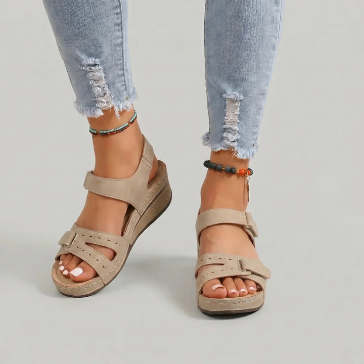 Clara Damen Keilsandalen in Beige mit verstellbaren Riemen und offener Zehenpartie, perfekt für müheloses Styling.