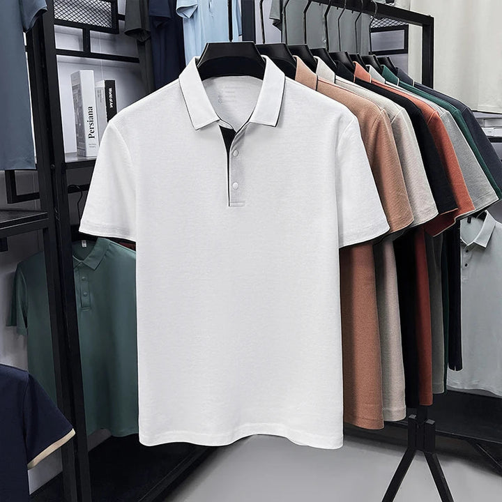 Weißes Herren-Poloshirt mit klassischem Kragen, Knopfleiste und kurzen Ärmeln auf einem Kleiderständer präsentiert.