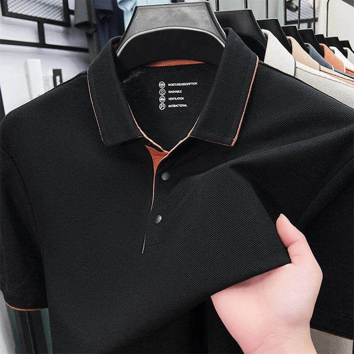 Schwarzes Herren-Poloshirt aus strukturiertem Funktionsstoff mit braunen Akzenten am Kragen und Knopfleiste.