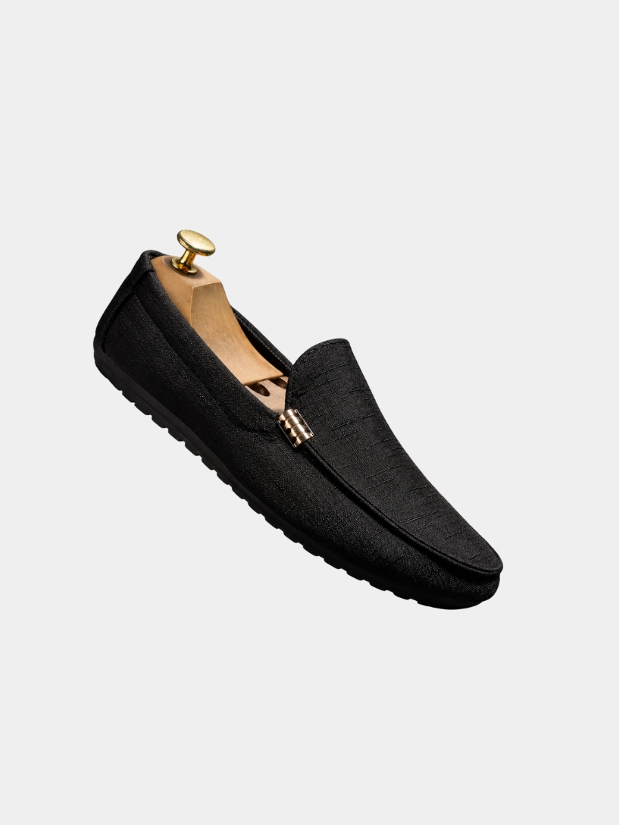Schwarzer Herren-Loafer aus strukturiertem Canvas mit Slip-On-Design und flexibler Sohle auf einem Schuhspanner.