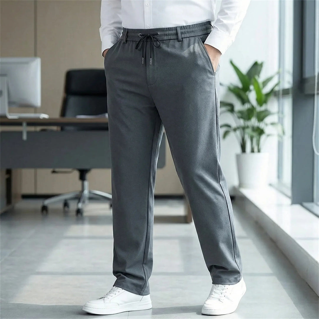 Dunkelgraue Herren-Stoffhose mit geradem Schnitt, elastischem Komfortbund, Kordelzug und praktischen Reißverschlusstaschen.