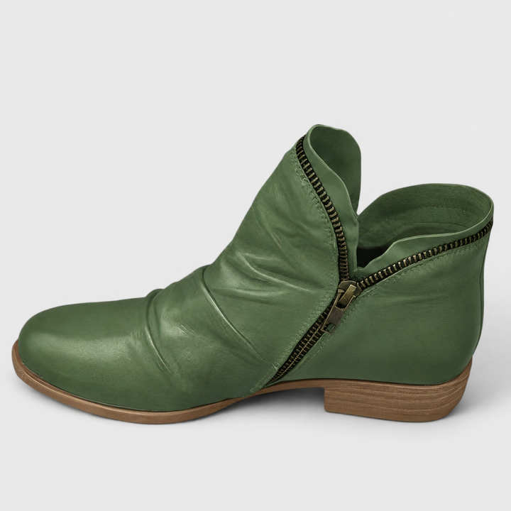 Grüne Damen-Stiefeletten in Lederoptik mit gerafftem Schaft, seitlichem Reißverschluss und niedrigem Blockabsatz.