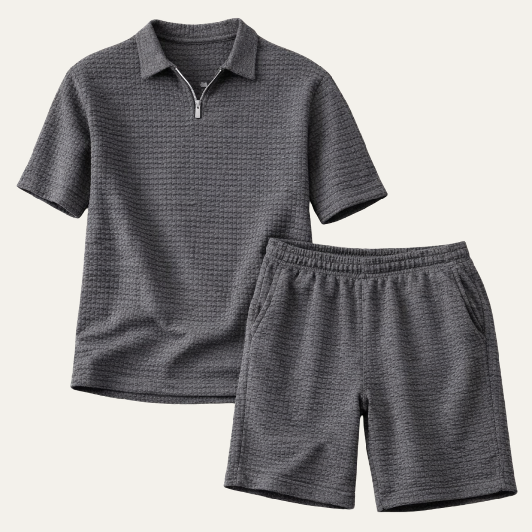 Dunkelgraues Herren-Set aus Waffelstoff mit Poloshirt, kurzem Reißverschluss und passenden Shorts mit elastischem Bund.