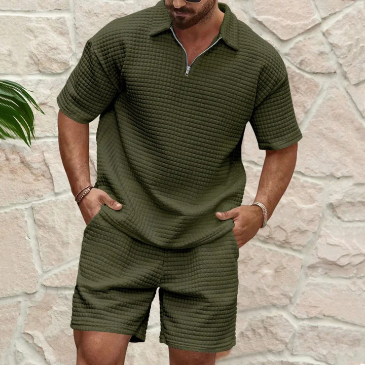 Olivgrünes Herren-Set aus Waffelstoff mit Poloshirt, Reißverschluss am Kragen und passenden Shorts im lockeren Schnitt.