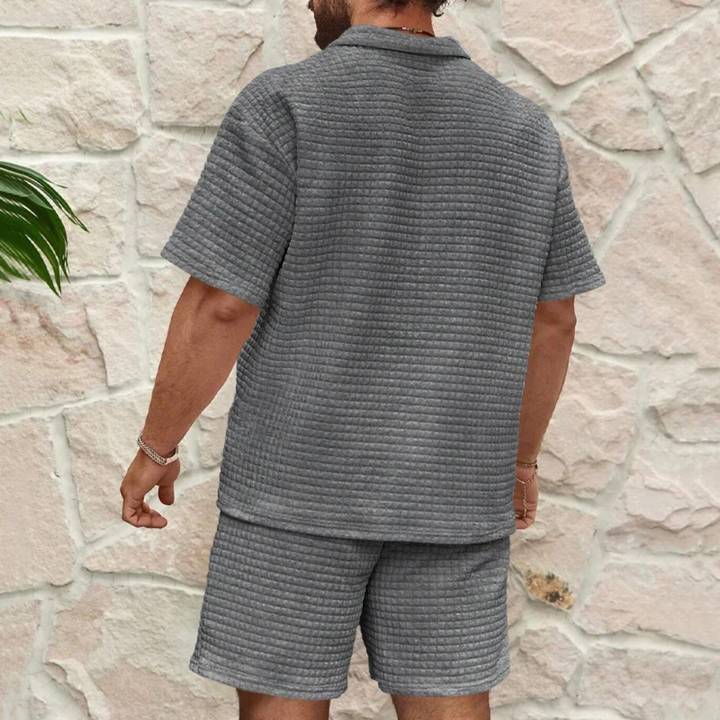Graues Herren-Sommerset mit Poloshirt und Shorts aus strukturiertem Waffelstoff in lockerer Passform.