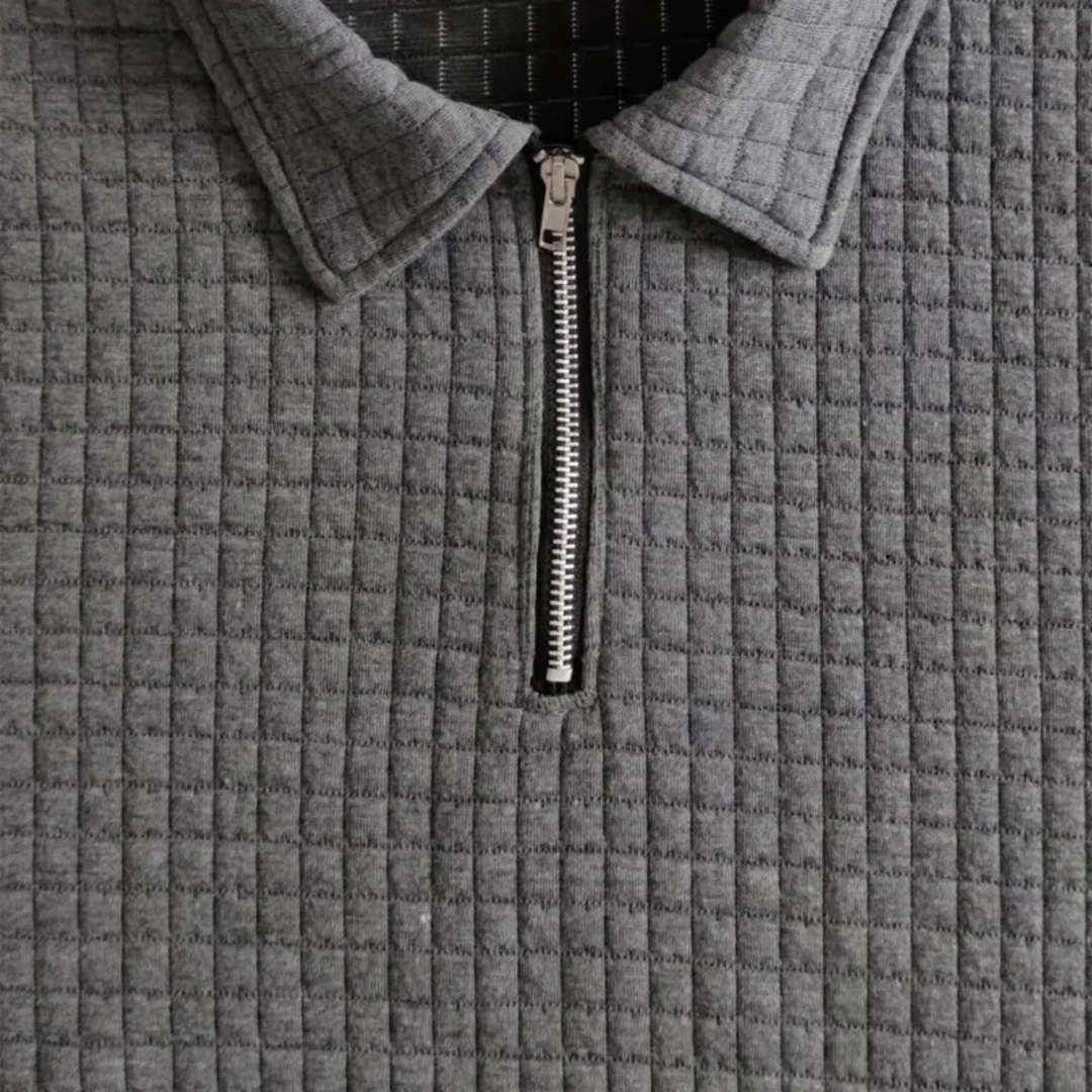 Dunkelgraues Herren-Poloshirt mit Waffelstruktur, Reißverschluss am Kragen und modernem, strukturiertem Stoffdesign.