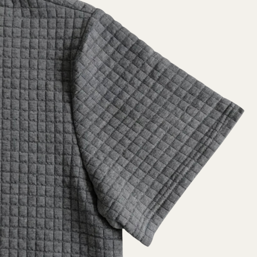 Dunkelgraues Herren-Poloshirt aus strukturiertem Waffelstoff mit kurzem Ärmel im lockeren Schnitt.