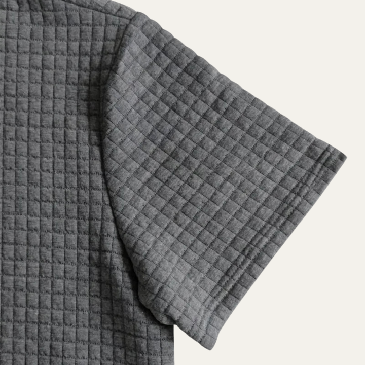 Dunkelgraues Herren-Poloshirt aus strukturiertem Waffelstoff mit kurzem Ärmel im lockeren Schnitt.