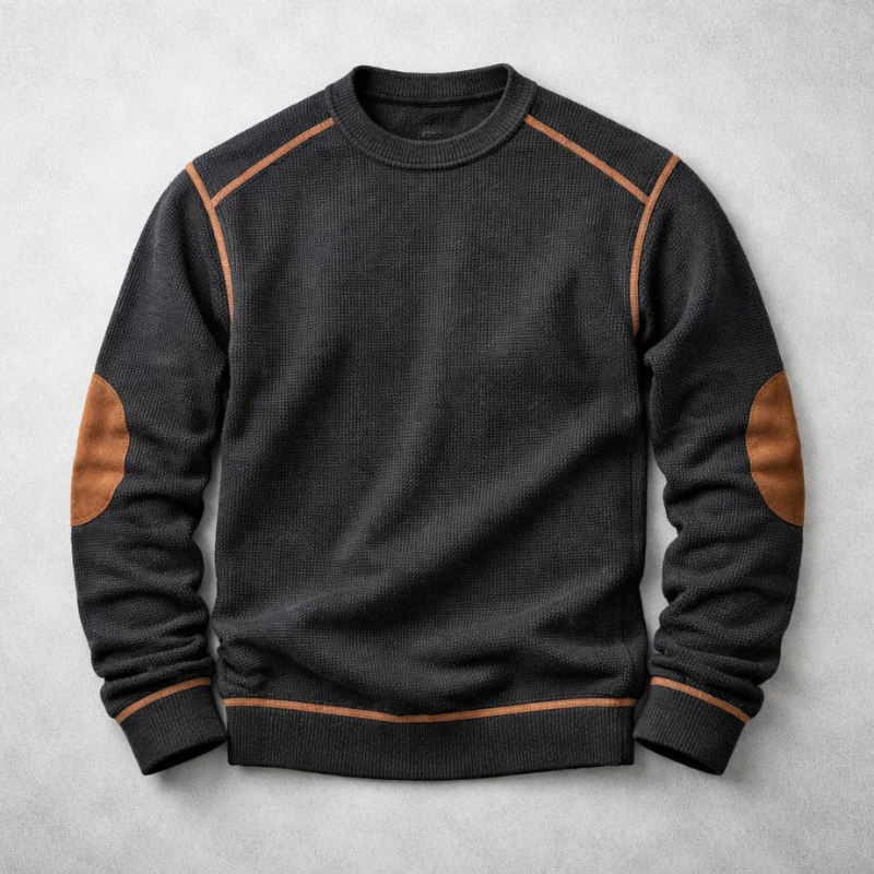 Schwarzer Herren-Strickpullover mit Waffelstruktur, Rundhalsausschnitt sowie braunen Ellbogen-Patches und Paspelierungen.