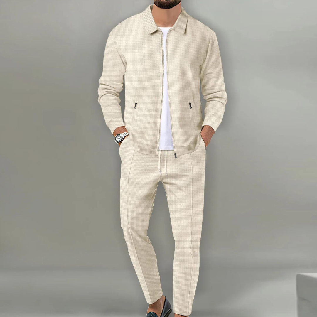 Beiger Herren-Zweiteiler in Waffeloptik mit Reißverschluss-Jacke, Hemdkragen und eleganter Hose für einen modernen Look.