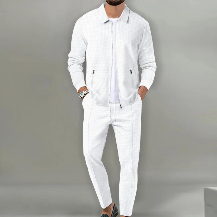 Weißer Herren-Zweiteiler in Waffeloptik mit Reißverschluss-Jacke, Hemdkragen und eleganter Hose für einen modernen Look.