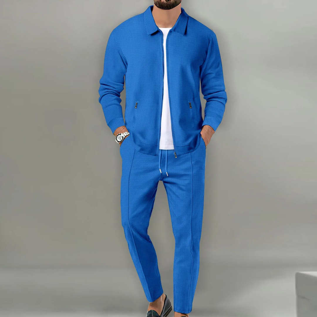 Blauer Herren-Zweiteiler in Waffeloptik mit Reißverschluss-Jacke, Hemdkragen und bequemer Hose mit Kordelzug.