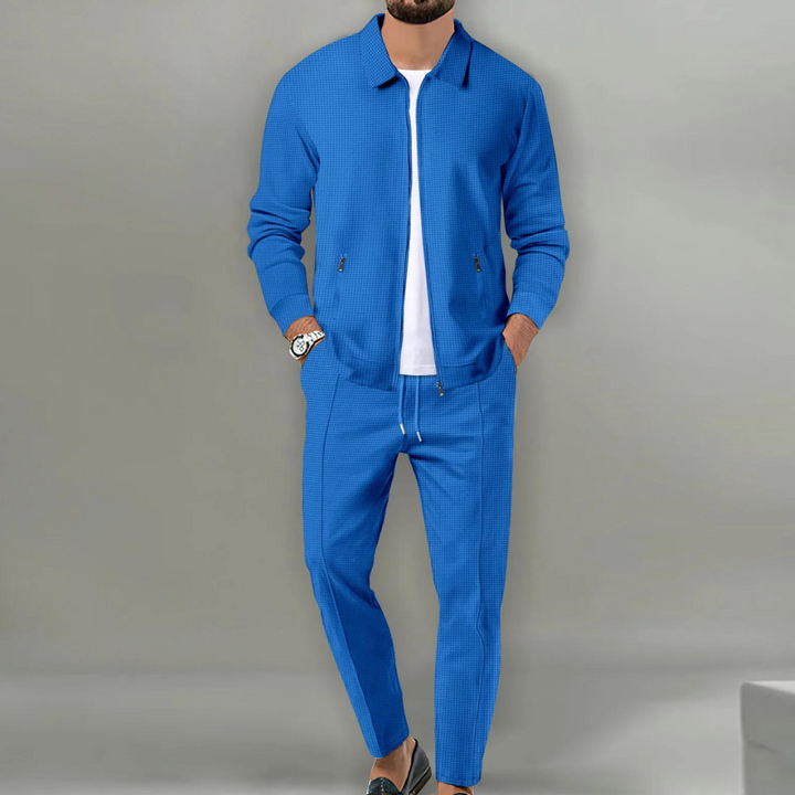 Blauer Herren-Zweiteiler in Waffeloptik mit Reißverschluss-Jacke, Hemdkragen und bequemer Hose mit Kordelzug.