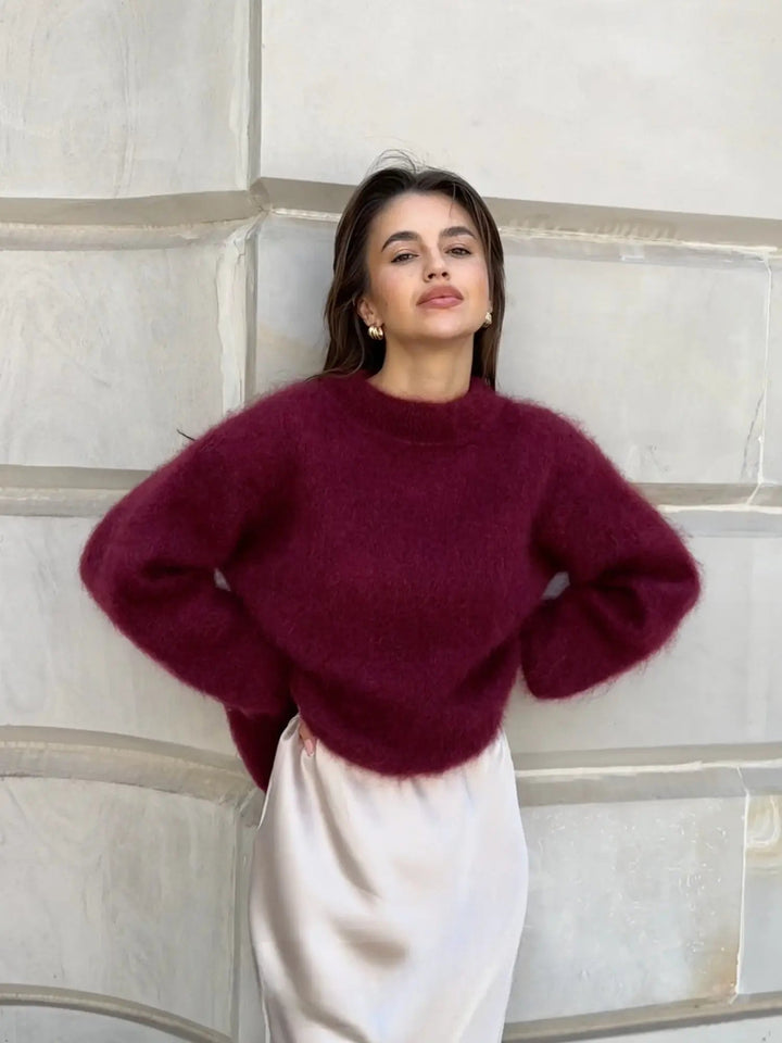 Flauschiger, weinroter Damen-Pullover mit Rundhals in lockerer Passform, kombiniert mit einem eleganten hellen Rock.