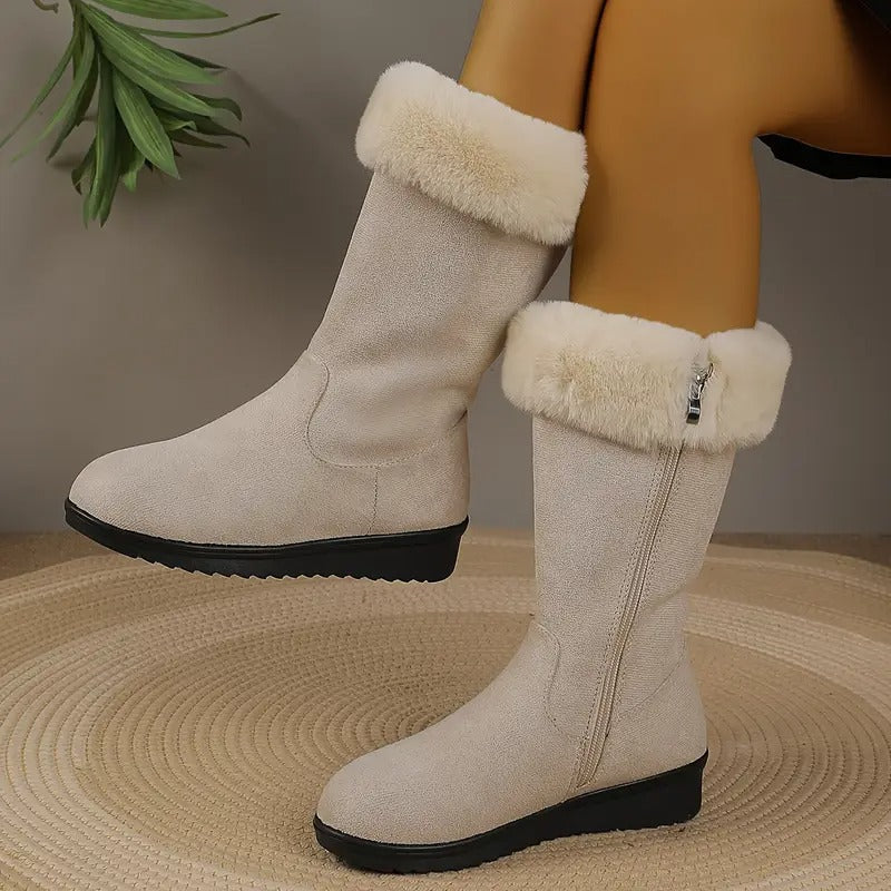 Beigefarbene, wadenhohe Emilia Winterstiefel mit weichem Fellbesatz, seitlichem Reißverschluss und schwarzer Profilsohle.