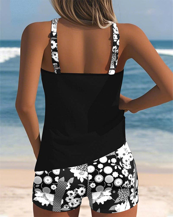 Schwarzer Emma Tankini von hinten mit geblümten Shorts am Strand