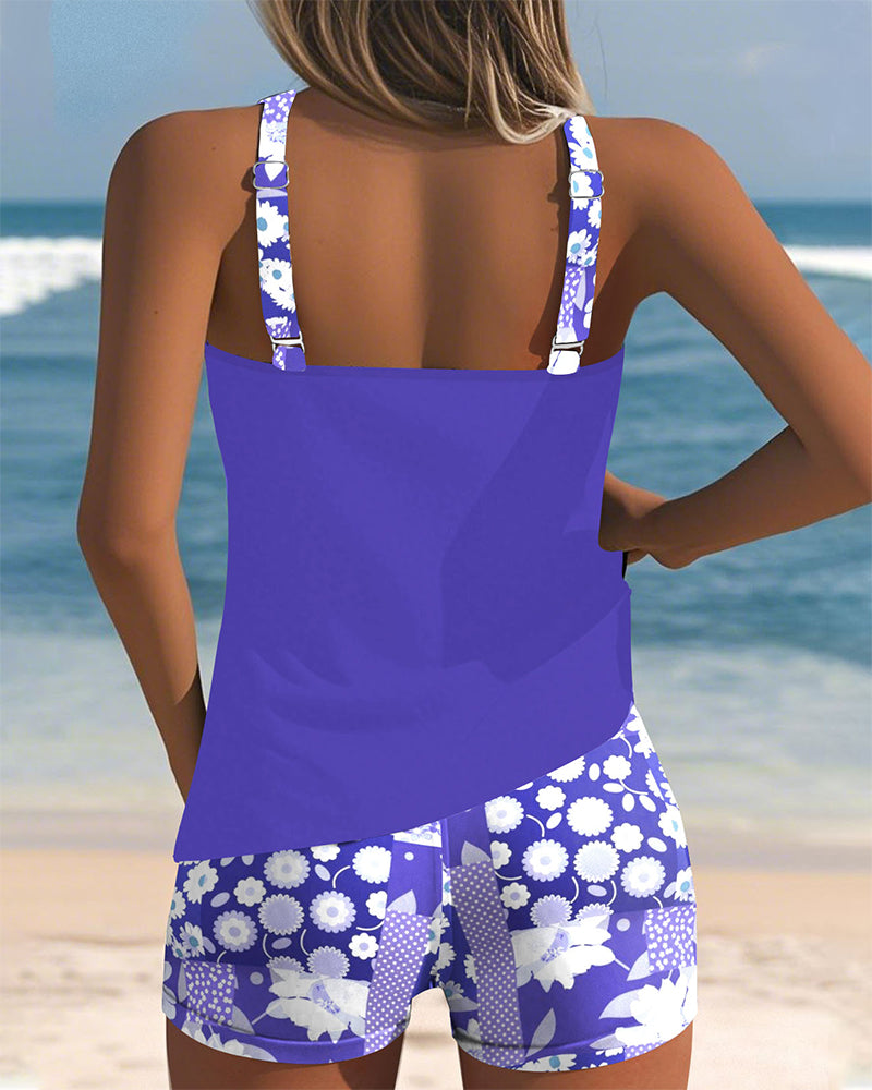 Blauer Emma Tankini von hinten mit geblümten Shorts am Strand