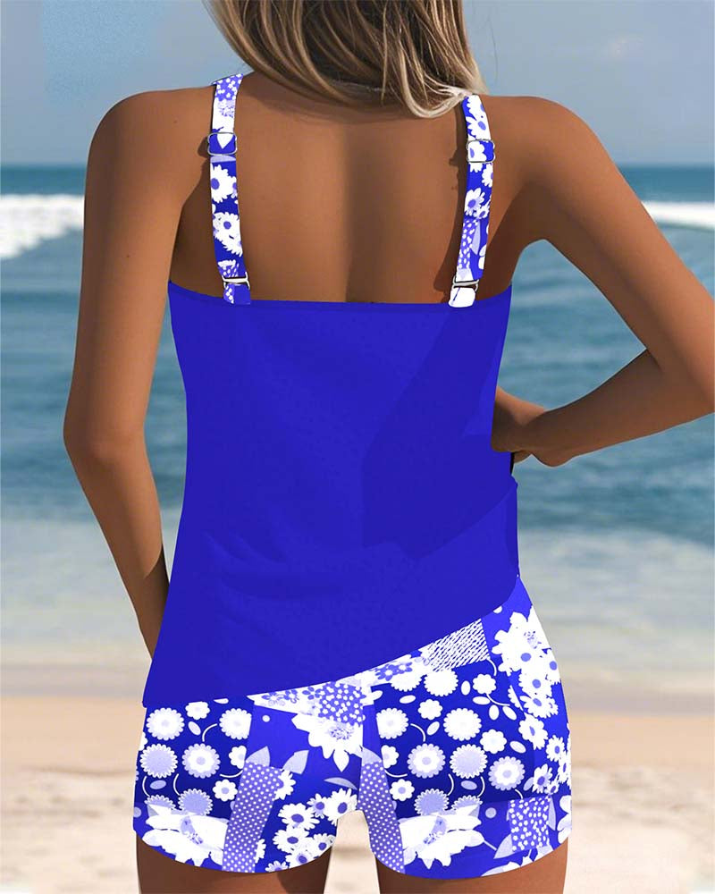 Blauer Emma Damen-Tankini von hinten mit geblümten Trägern und passenden Shorts am Strand.