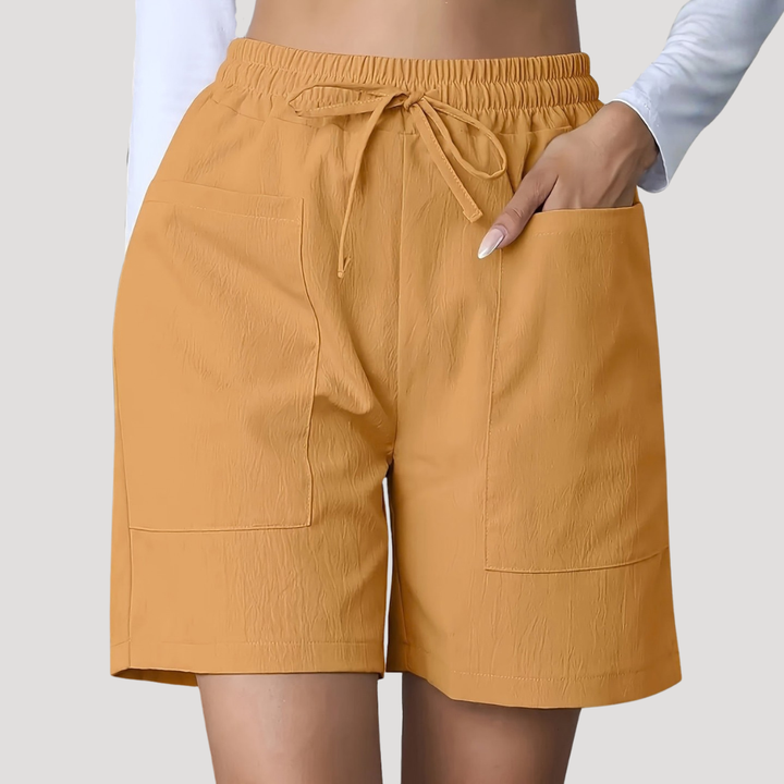 Senfgelbe, lockere Damen-Shorts mit Kordelzug, elastischem Bund und großen aufgesetzten Seitentaschen.