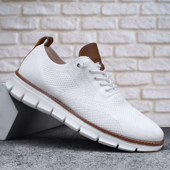 Weißer Herren-Sneaker aus atmungsaktivem Mesh mit braunen Lederoptik-Details und flexibler, gerillter Laufsohle.