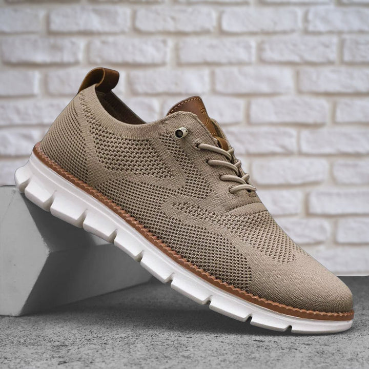 Beiger Herren-Sneaker aus atmungsaktivem Mesh mit braunen Lederoptik-Details und weißer, flexibler Laufsohle.