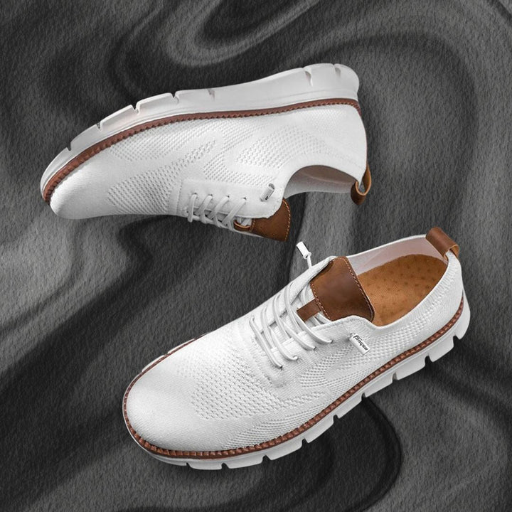 Weiße Herren-Mesh-Sneaker mit braunen Lederoptik-Details und flexibler weißer Laufsohle auf dunklem Hintergrund.