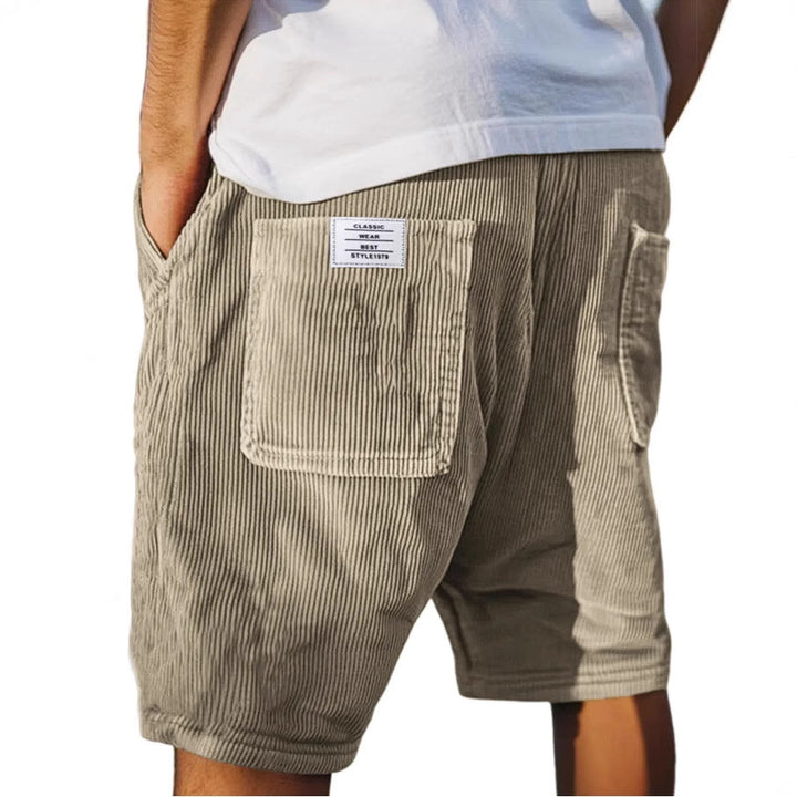 Beige Herren-Samtshorts im Relaxed Fit mit elastischem Bund und aufgesetzter Gesäßtasche mit Label-Patch.
