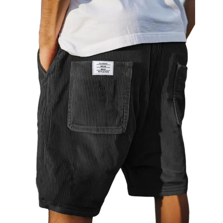 Schwarze Herren-Shorts aus geripptem Samt mit elastischem Bund und aufgesetzter Gesäßtasche im Relaxed Fit.