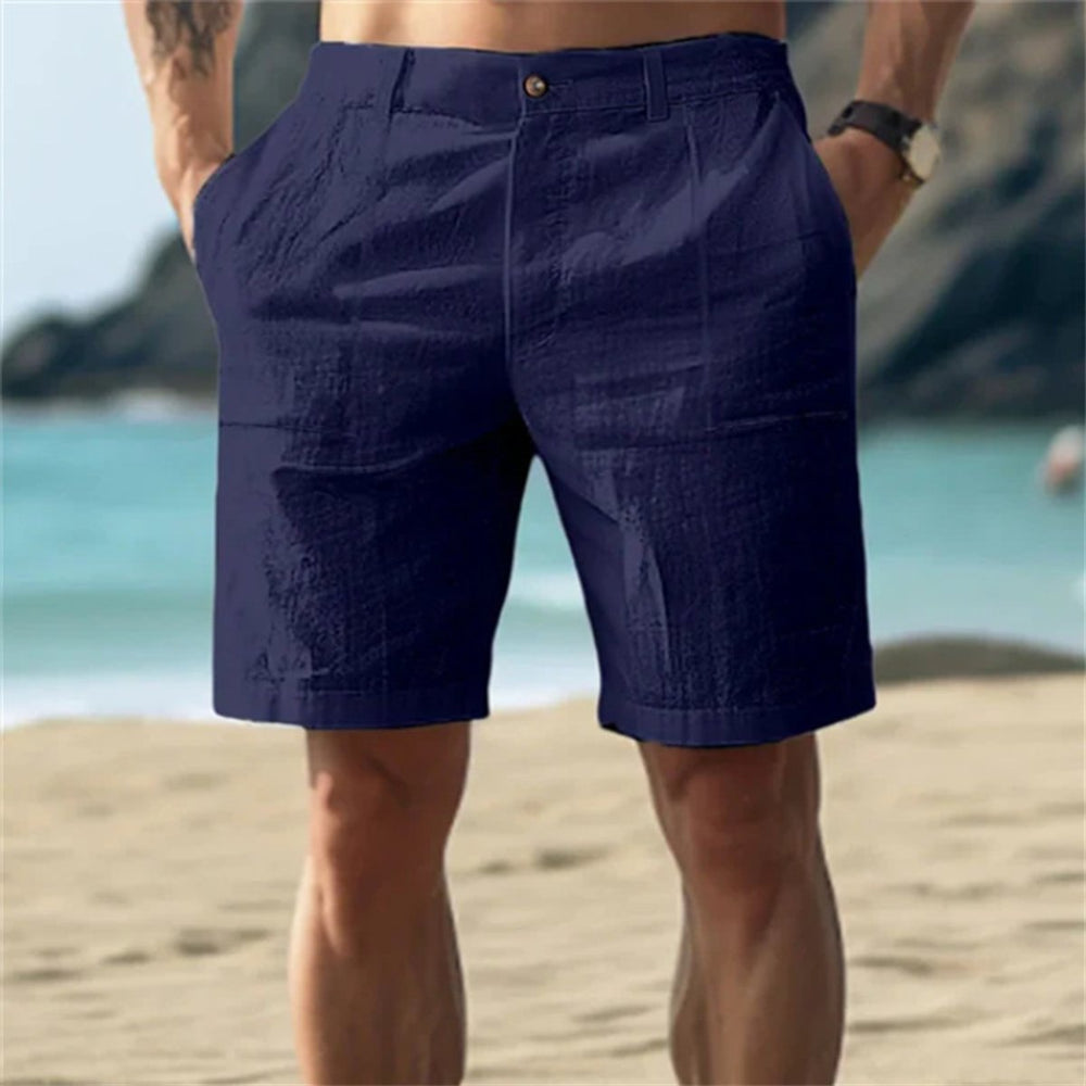 Dunkelblaue Herren-Leinenshorts mit elastischem Bund und Seitentaschen in lockerer Passform am Strand.