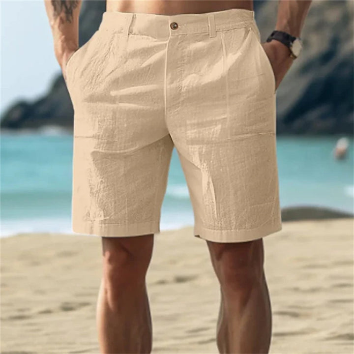 Beigefarbene Herren-Leinenshorts mit elastischem Bund und Seitentaschen in lockerer Passform am Strand.