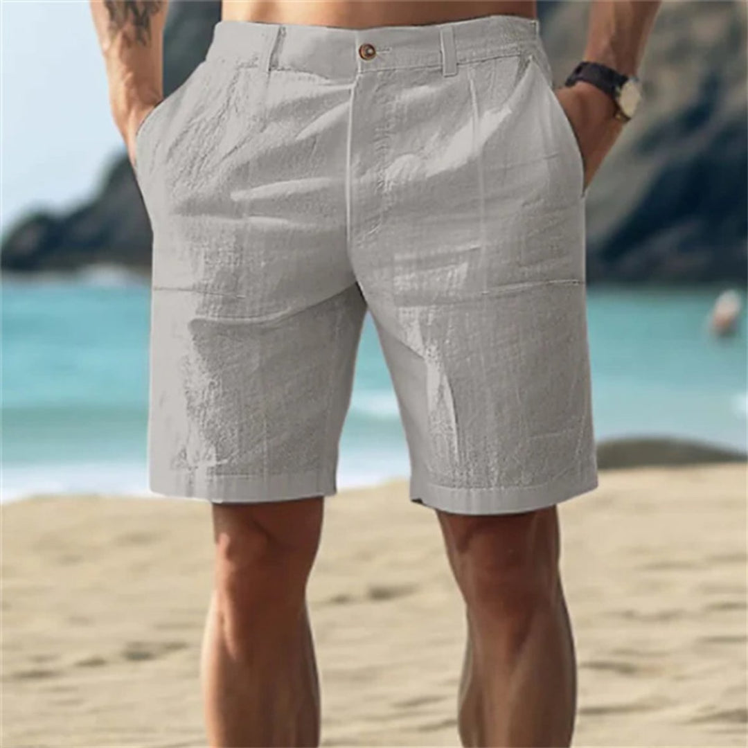 Hellgraue Herren-Leinenshorts mit elastischem Bund und Seitentaschen in lockerer Passform am Strand.